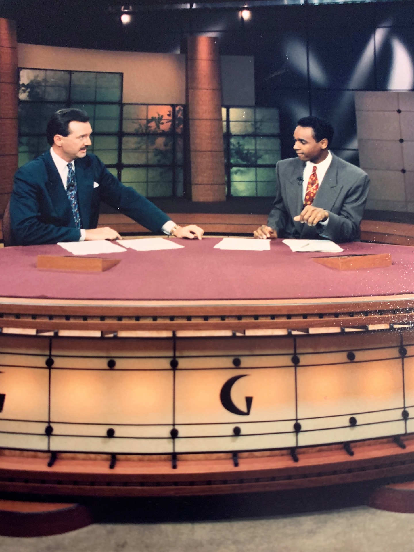 Dwayne Ballen gesturing from The Golf Channel anchor desk alongside a co-anchor