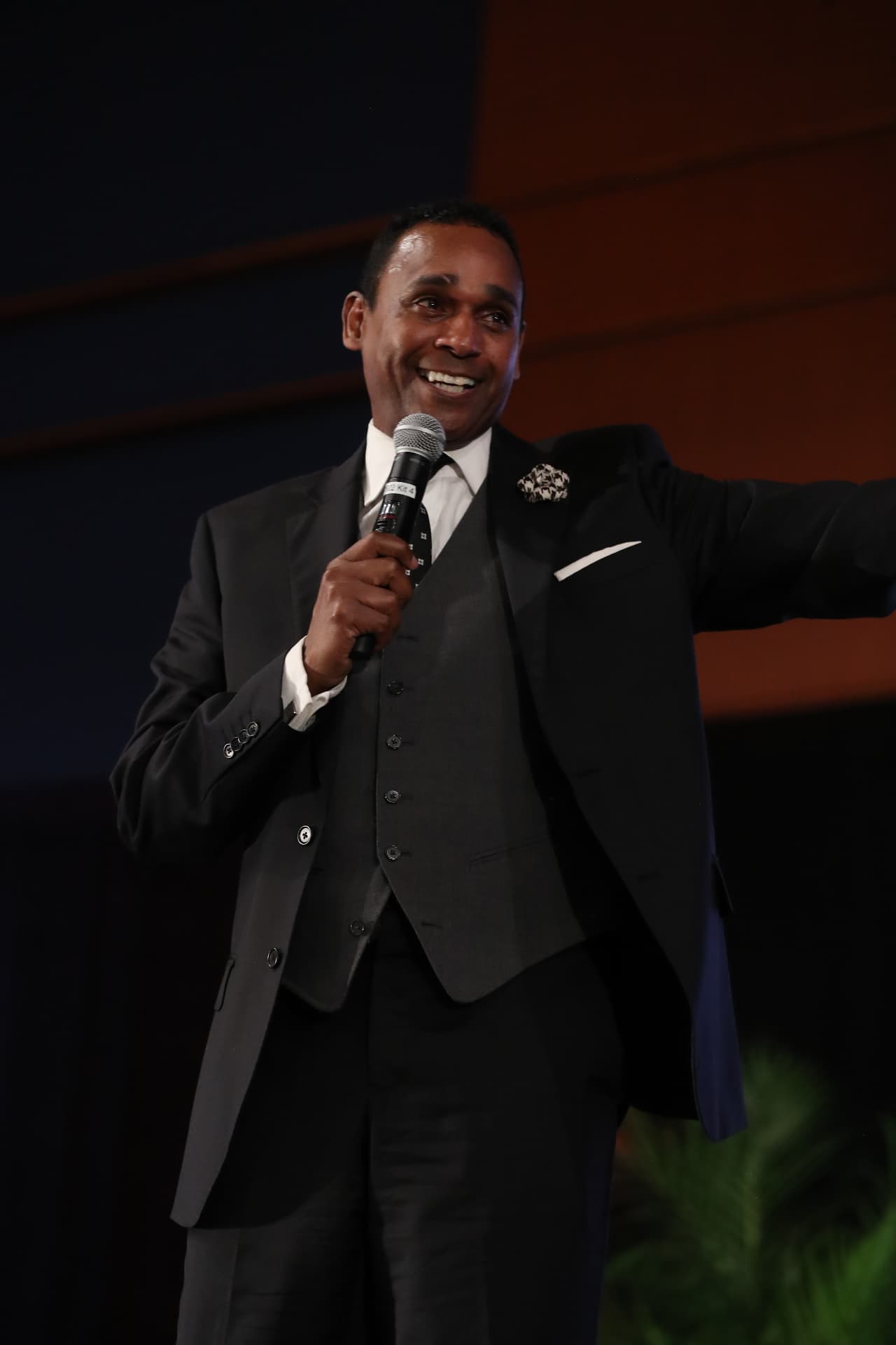 Dwayne Ballen speaking onstage with a handheld microphone