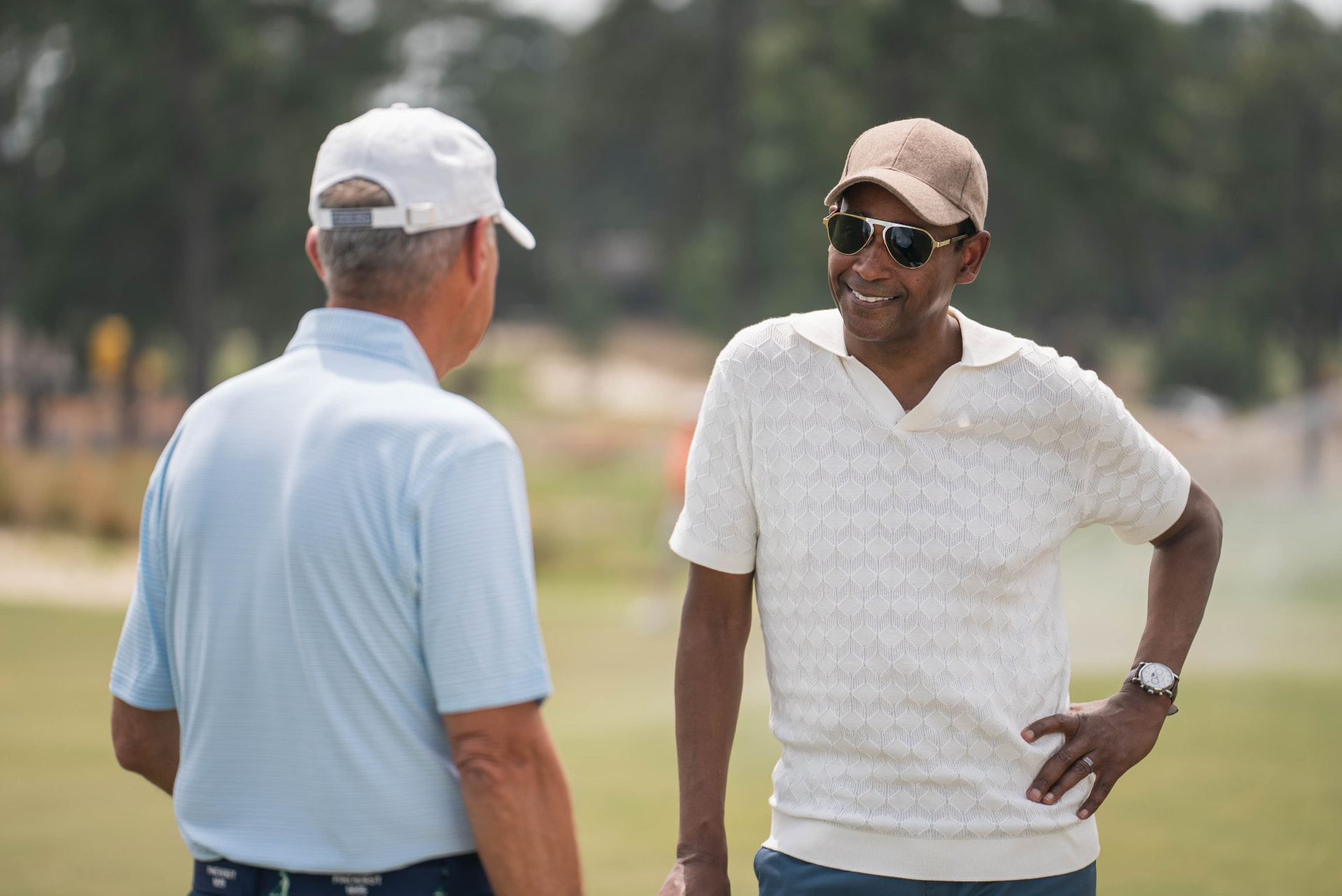 Dwayne Ballen in conversation with a guest on a golf course during a PBS documentary production