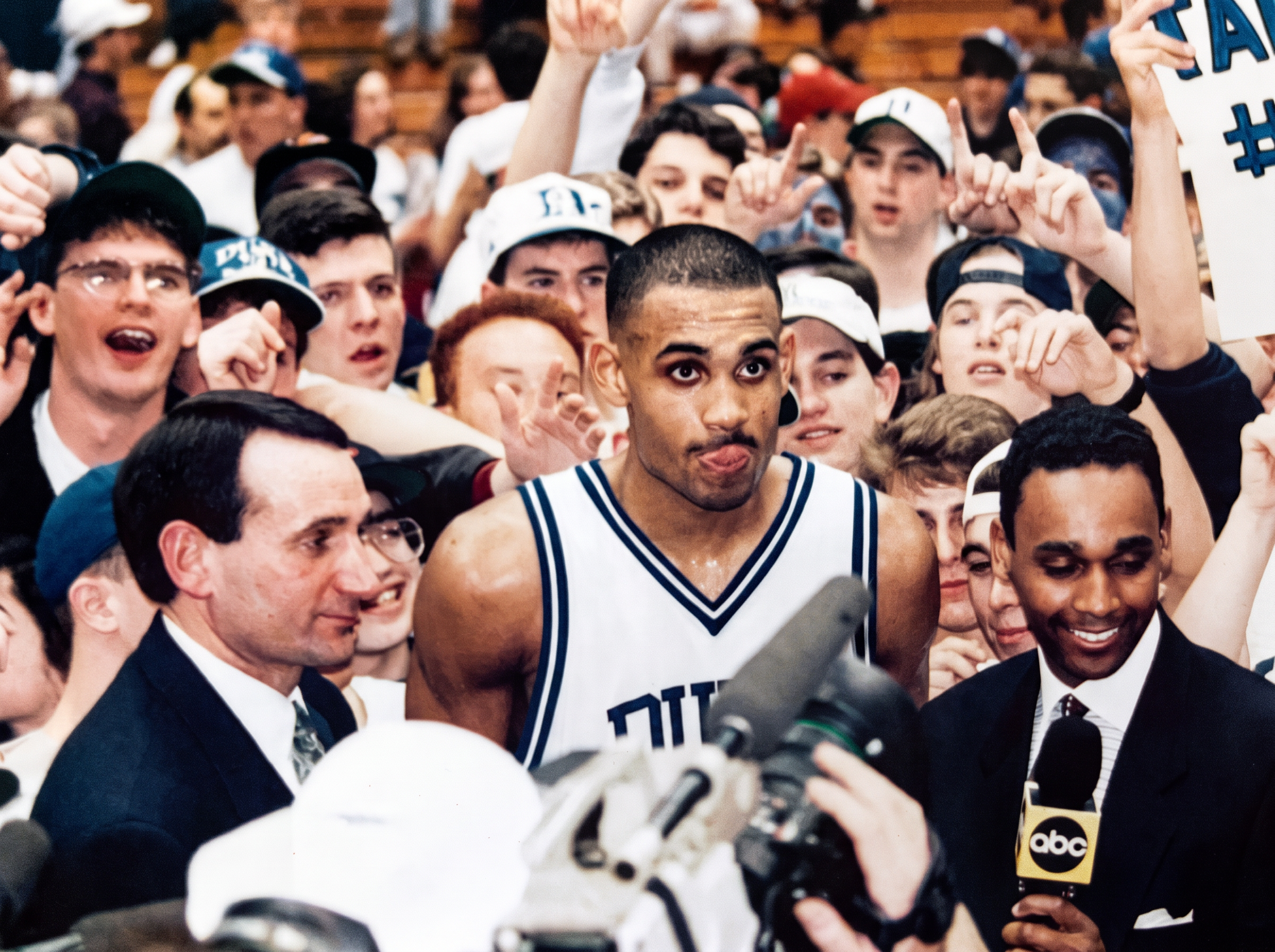 Dwayne Ballen reporting courtside for ABC Sports amid a postgame crowd after a Duke basketball game