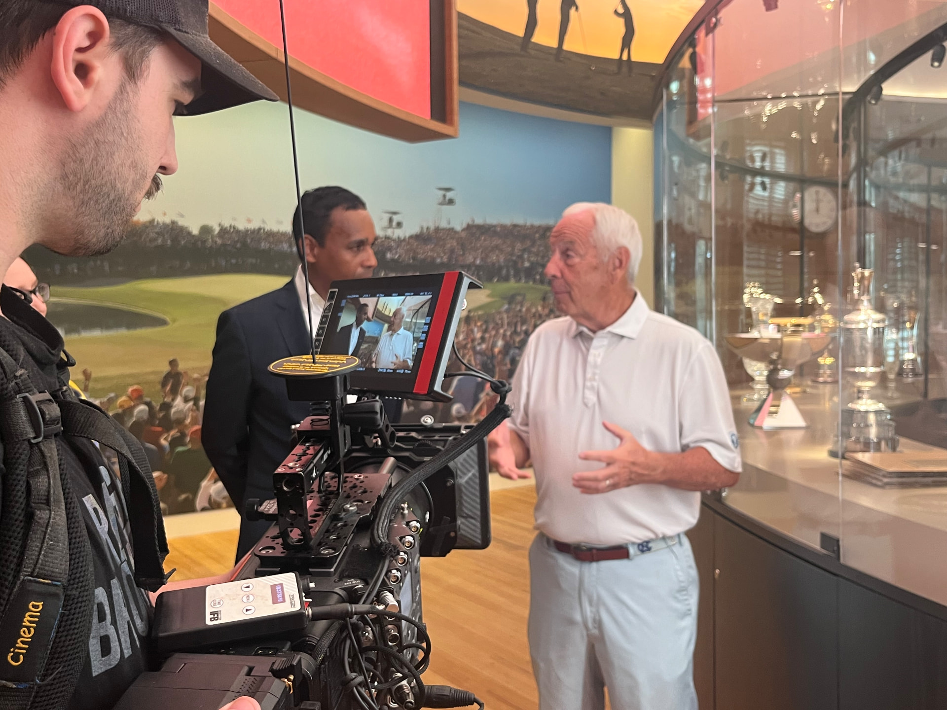 Dwayne Ballen conducting an on-camera interview on location with a cinema camera and crew in the foreground