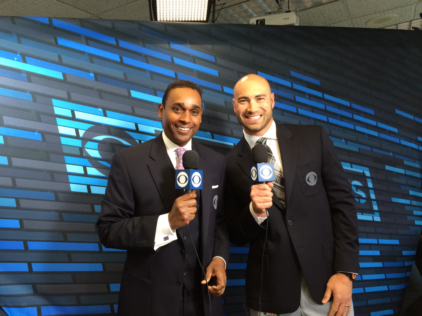 Dwayne Ballen holding a CBS Sports microphone with a colleague on set