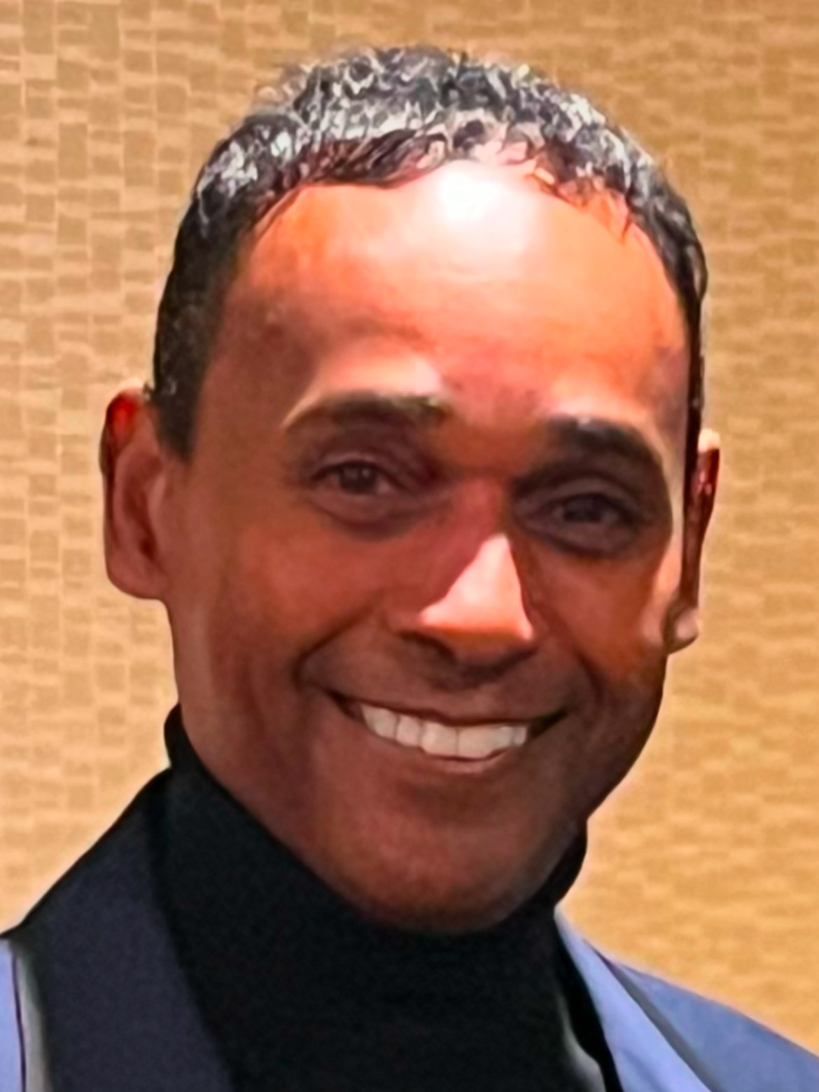 Close editorial portrait of Dwayne Ballen smiling at an indoor event
