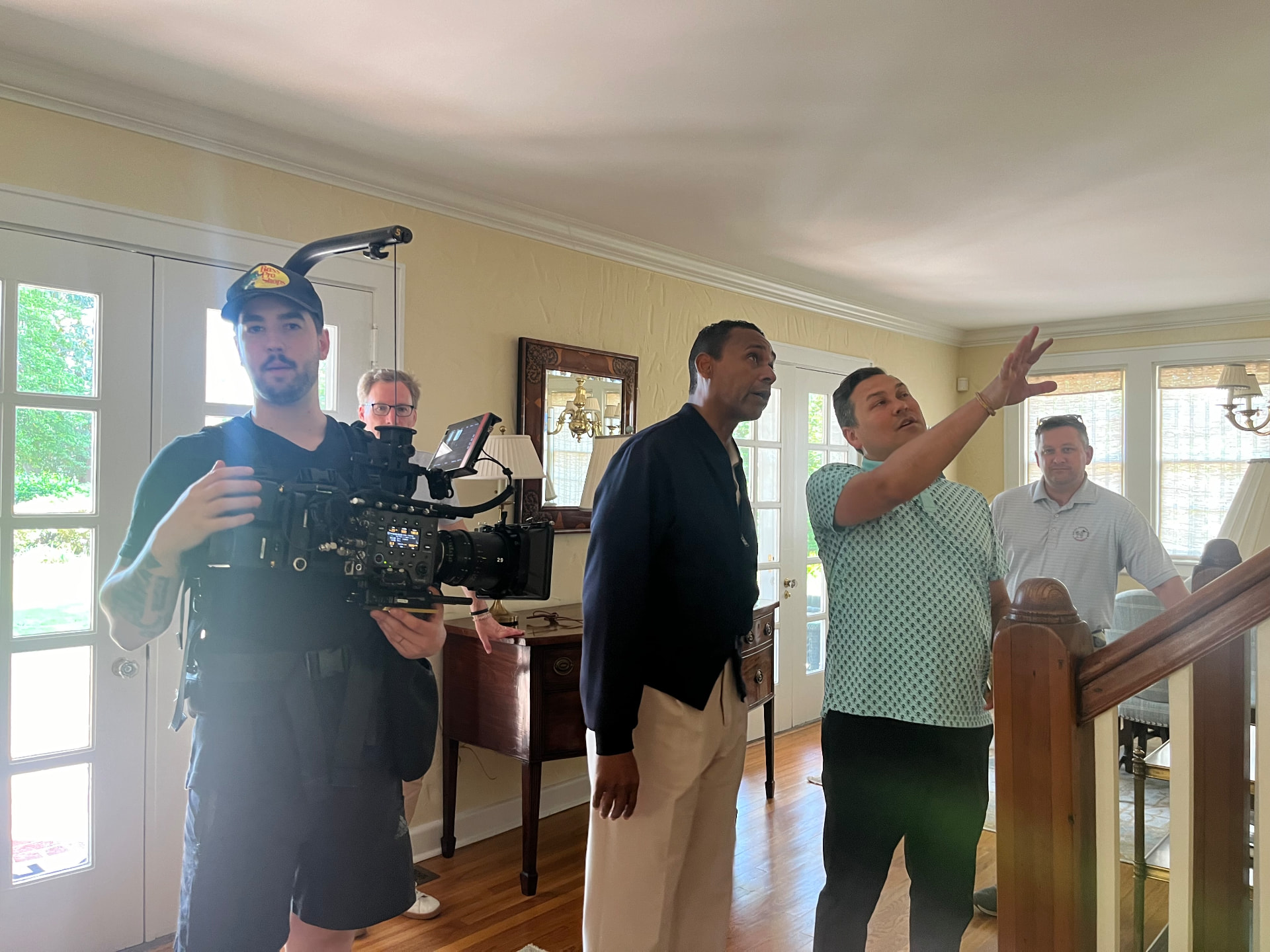 Dwayne Ballen directing a scene on location while a camera operator films in a residential interior