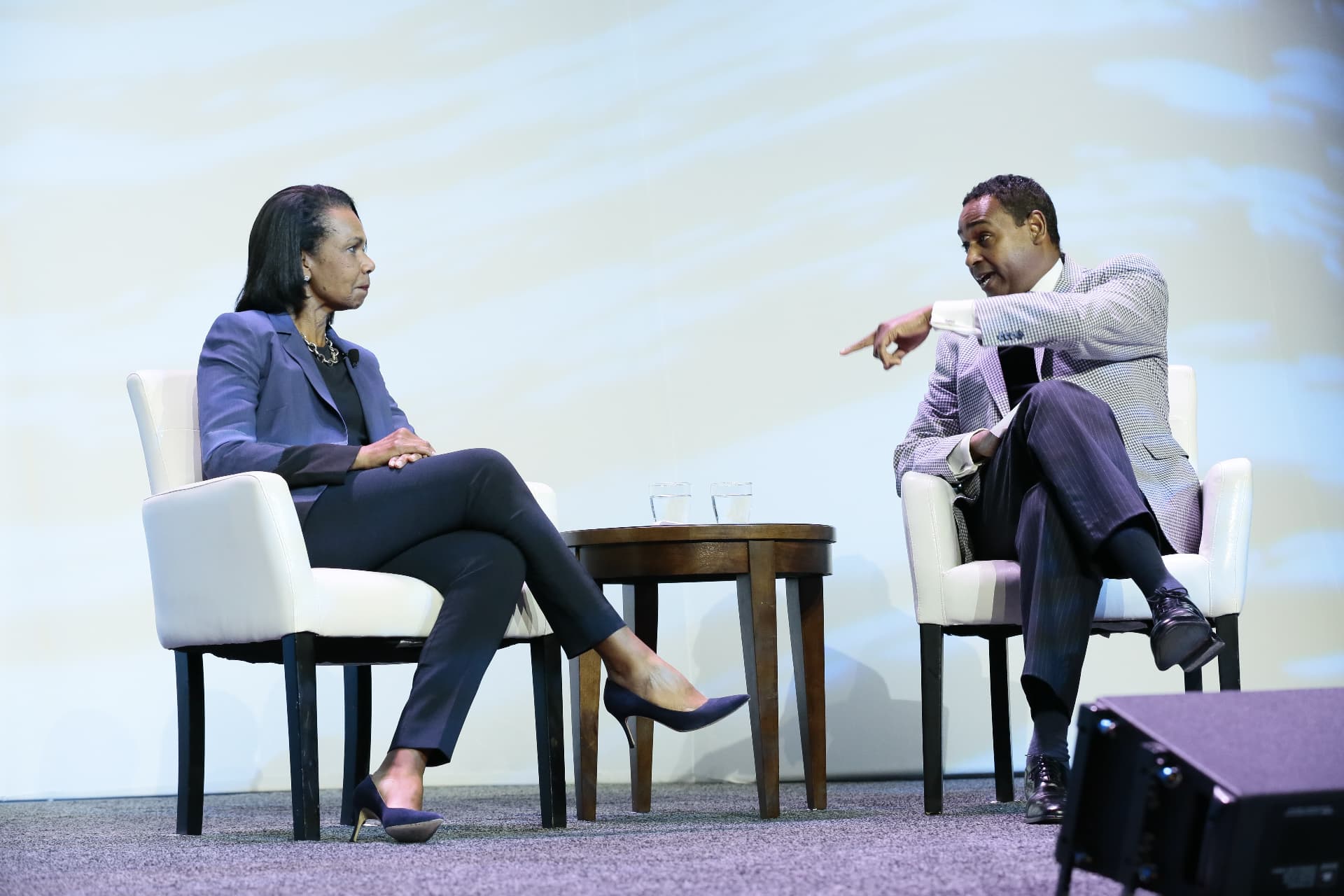 Dwayne Ballen gesturing while interviewing Condoleezza Rice on a conference stage